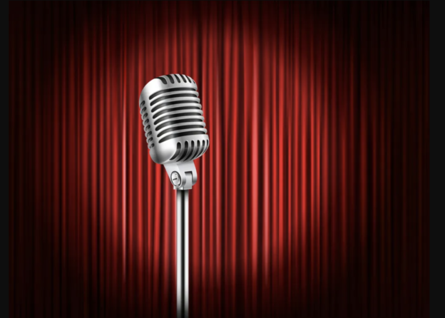 a microphone in a spotlight in front of a red curtain